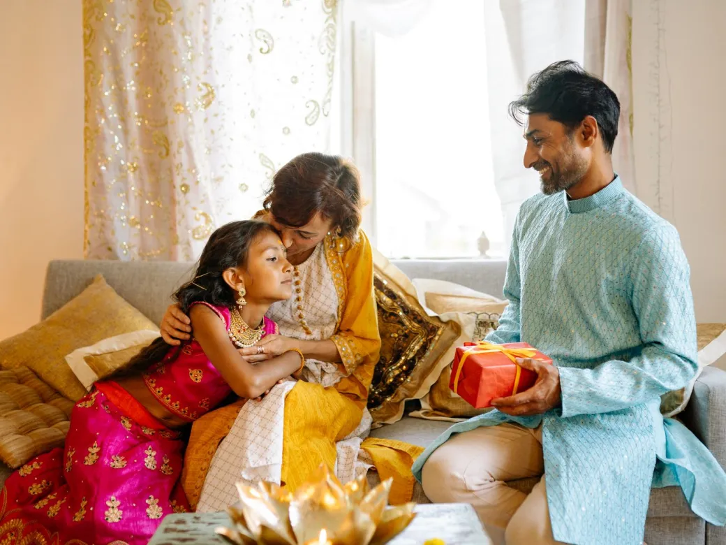 An Indian family sitting together at home, sharing gifts
